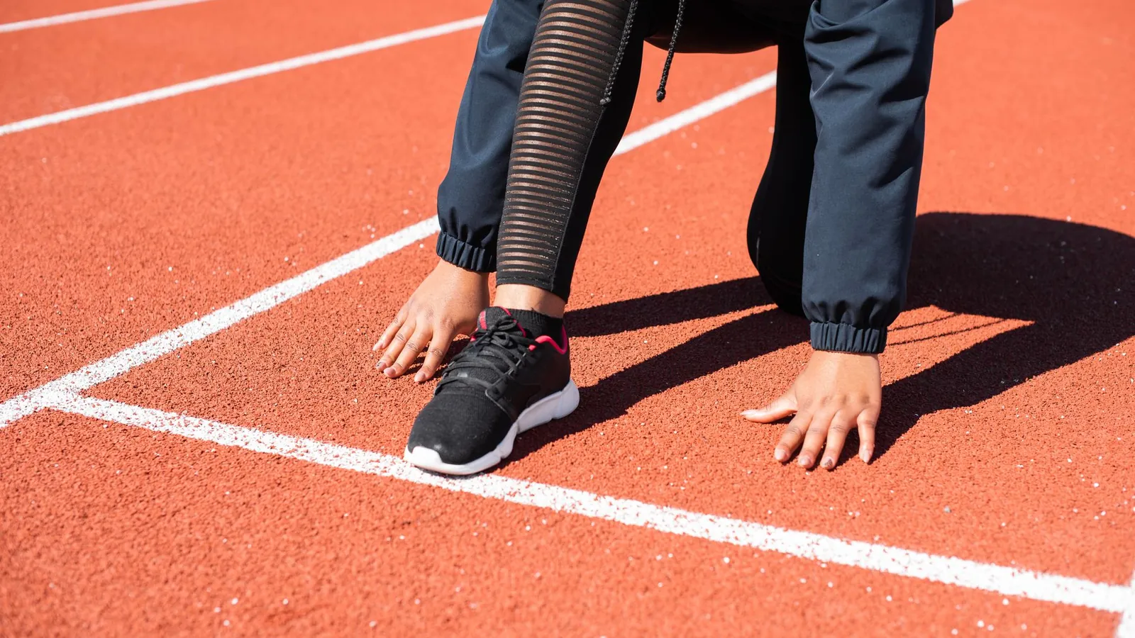 A runner crouched in the start position on a running track