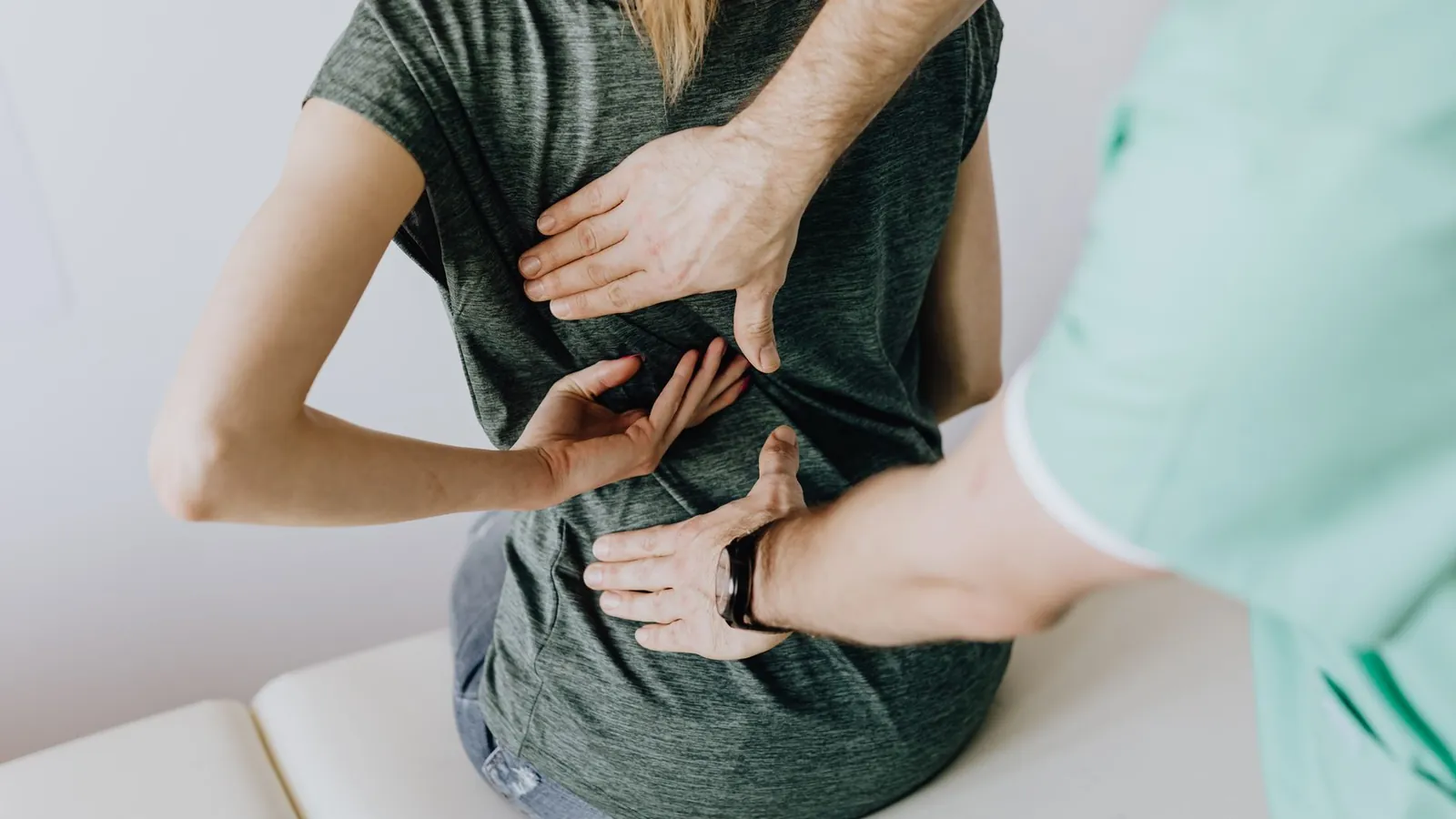 A physiotherapist examining a patient's lower back