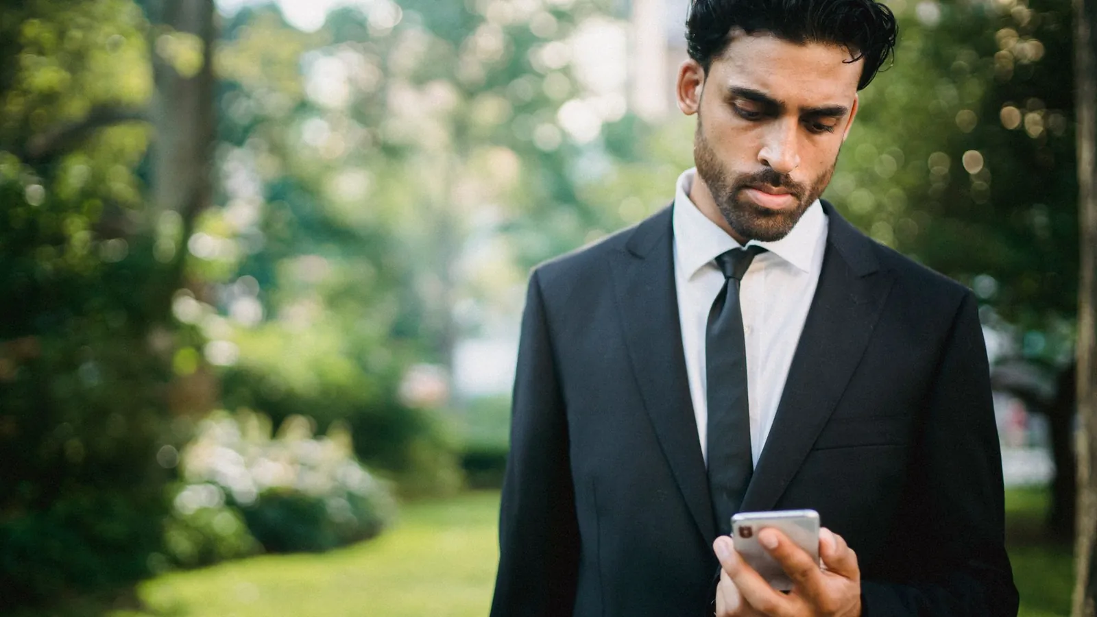 A man looking down at his phone with his neck bent forward