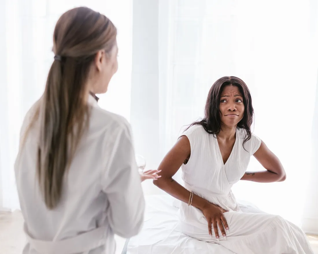 A patient describing her lower back pain to a physiotherapist during a consultation